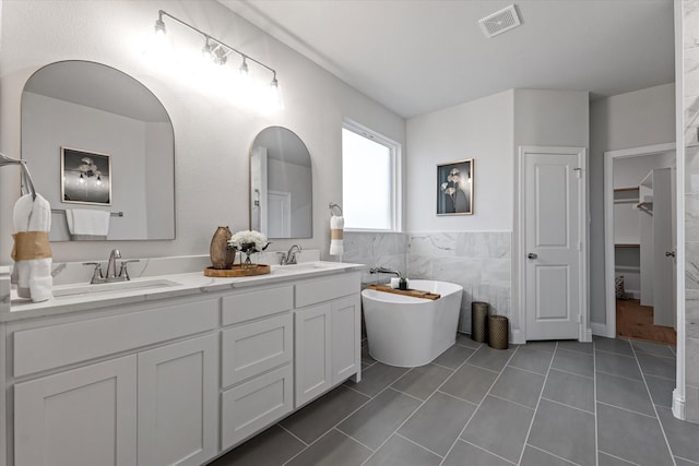 913 Beall St, Denton, TX 76207 - full bath featuring a sink, double vanity, visible vents, and a freestanding tub
