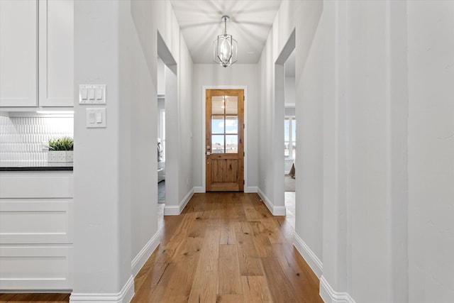 913 Beall St, Denton, TX 76207 - entryway with baseboards, a notable chandelier, and light wood-style flooring