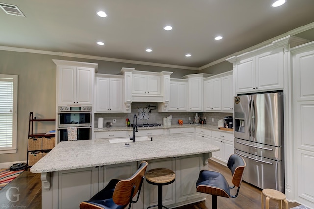 kitchen with ornamental molding, stainless steel appliances, dark wood-style floors, and visible vents