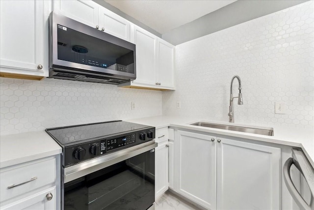 kitchen featuring light countertops, appliances with stainless steel finishes, decorative backsplash, and a sink
