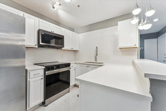 kitchen with a sink, a peninsula, marble finish floor, light countertops, and appliances with stainless steel finishes