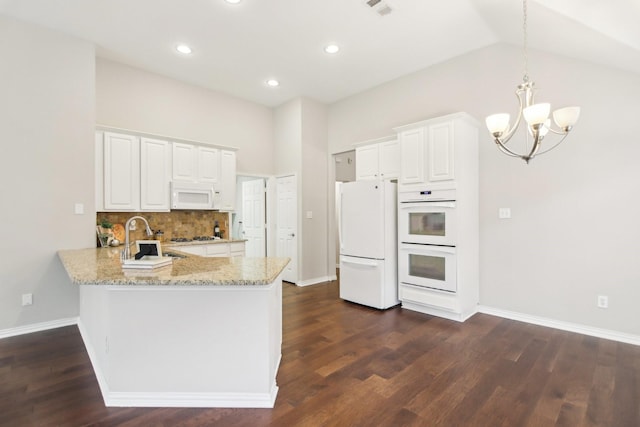 4118 Armistice Dr, Frisco, TX 75034 - kitchen with a peninsula, an inviting chandelier, a sink, light stone countertops, and white appliances