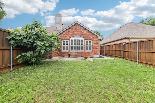 4118 Armistice Dr, Frisco, TX 75034 - rear view of house featuring a chimney, a lawn, brick siding, a patio, and a fenced backyard