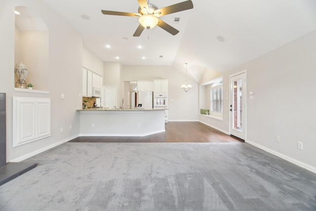 4118 Armistice Dr, Frisco, TX 75034 - unfurnished living room with ceiling fan with notable chandelier, high vaulted ceiling, visible vents, dark colored carpet, and baseboards