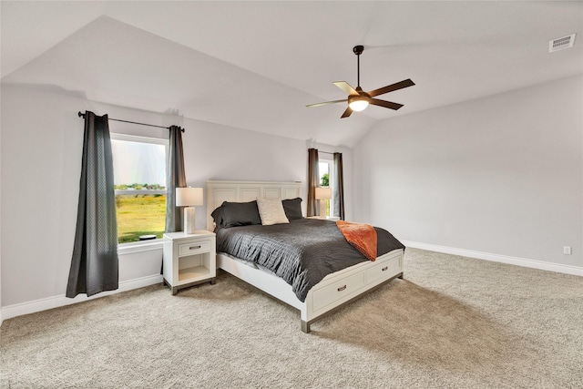 carpeted bedroom with baseboards, multiple windows, visible vents, and vaulted ceiling