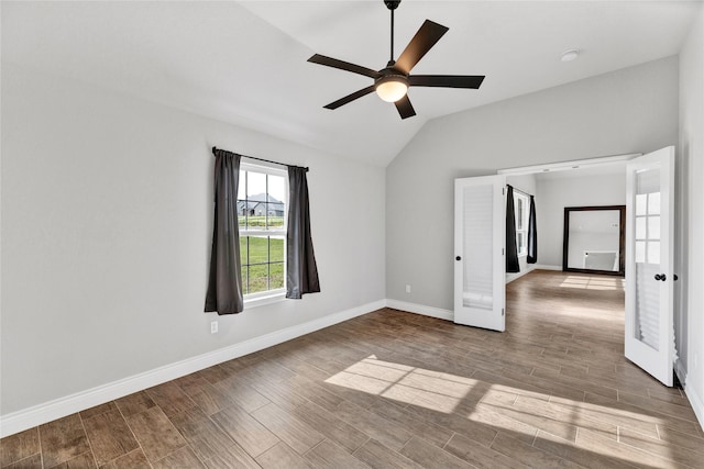 empty room with lofted ceiling, french doors, baseboards, ceiling fan, and wood finished floors