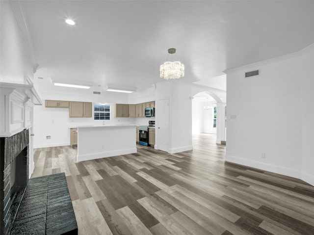 unfurnished living room with light wood finished floors, an inviting chandelier, a brick fireplace, visible vents, and arched walkways