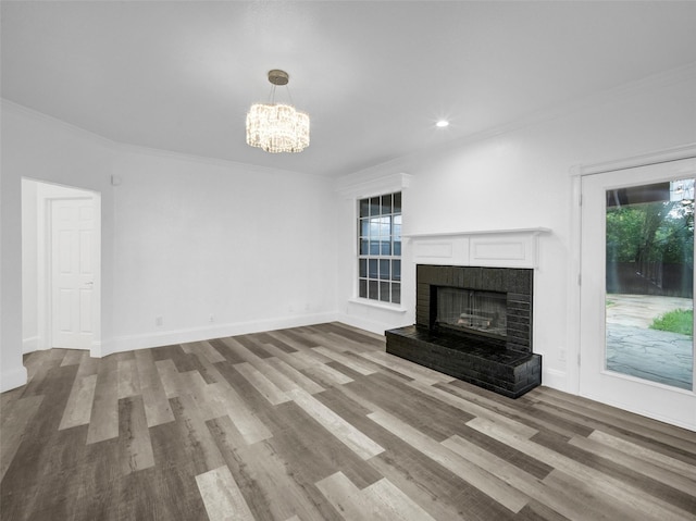 unfurnished living room featuring crown molding, wood finished floors, and a notable chandelier