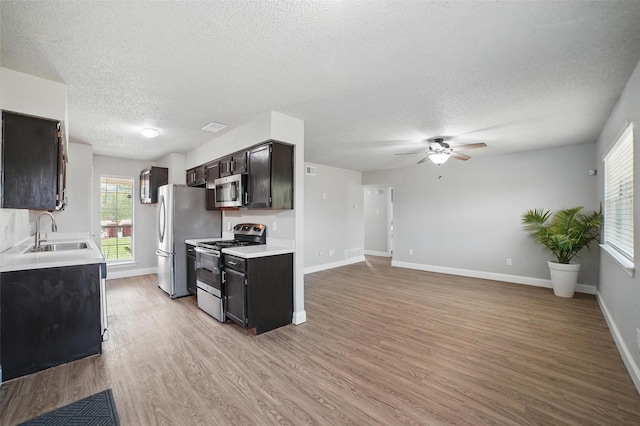 704 Loganwood Dr, Royse City, TX 75189 - kitchen featuring appliances with stainless steel finishes, a sink, a textured ceiling, ceiling fan, and light countertops