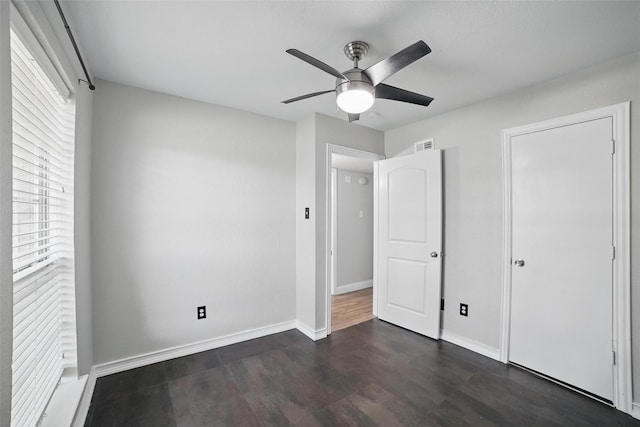 704 Loganwood Dr, Royse City, TX 75189 - unfurnished bedroom with dark wood finished floors, baseboards, and ceiling fan