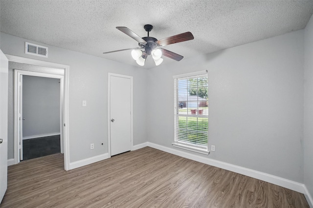 704 Loganwood Dr, Royse City, TX 75189 - unfurnished bedroom with wood finished floors, a textured ceiling, baseboards, a ceiling fan, and a closet