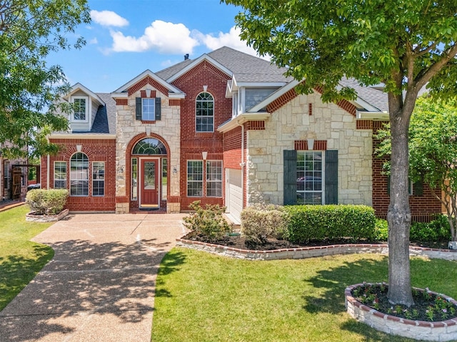 traditional home with stone siding, roof with shingles, a front lawn, and brick siding