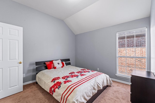 carpeted bedroom with lofted ceiling and baseboards