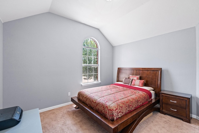 bedroom with vaulted ceiling, light carpet, and baseboards