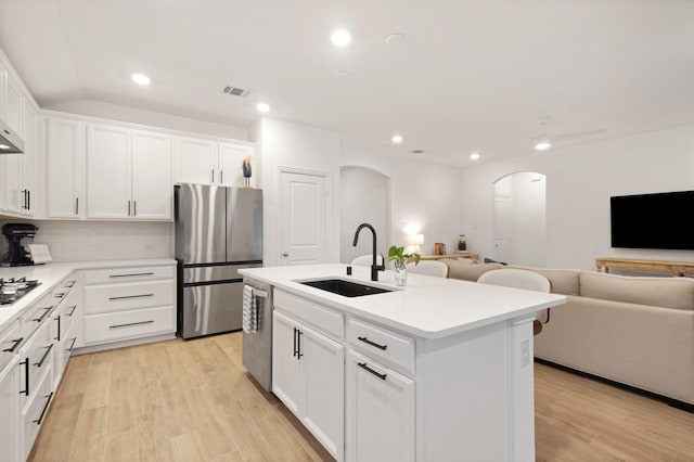 4025 Wild Turkey Dr, Hickory Creek, TX 75065 - kitchen with a sink, appliances with stainless steel finishes, arched walkways, open floor plan, and light wood-style flooring