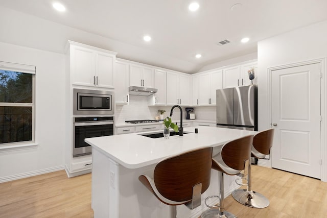 4025 Wild Turkey Dr, Hickory Creek, TX 75065 - kitchen with stainless steel appliances, a sink, under cabinet range hood, light wood-style floors, and recessed lighting