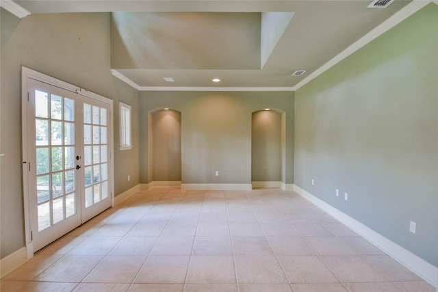 empty room featuring french doors, light tile patterned floors, baseboards, crown molding, and arched walkways