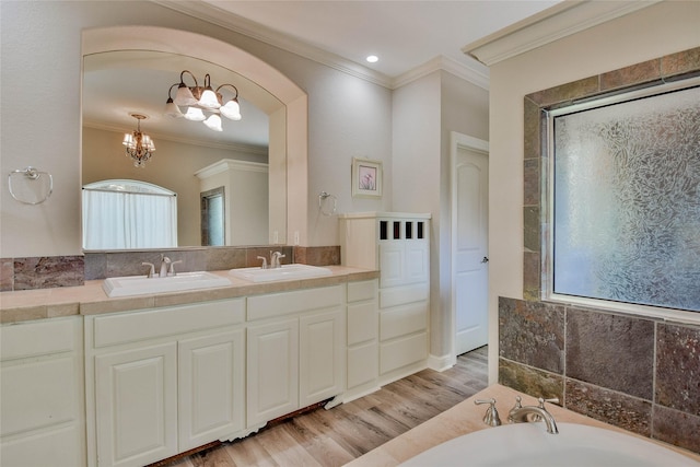 full bathroom featuring a sink, ornamental molding, a garden tub, and wood finished floors