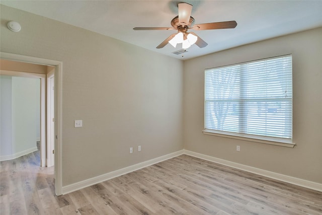 empty room featuring ceiling fan, light wood-style flooring, baseboards, and visible vents