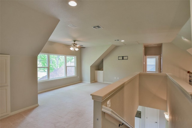 additional living space featuring light carpet, visible vents, and plenty of natural light