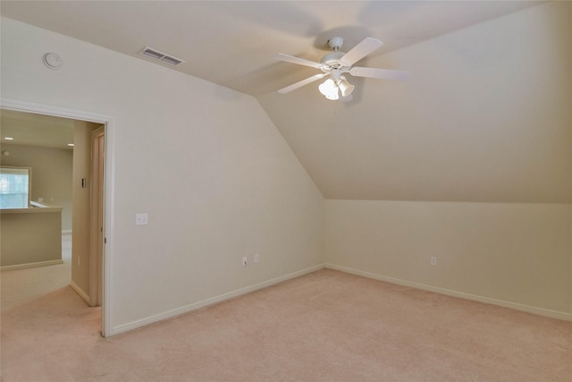 bonus room with baseboards, ceiling fan, visible vents, vaulted ceiling, and light carpet