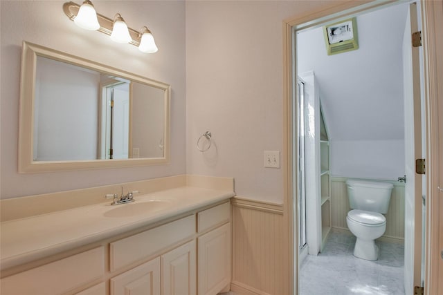 full bathroom featuring wainscoting, vanity, toilet, and a shower