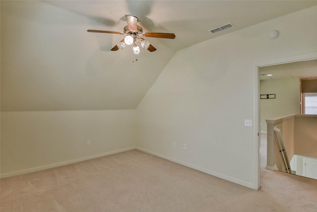 additional living space with a ceiling fan, light carpet, visible vents, baseboards, and vaulted ceiling
