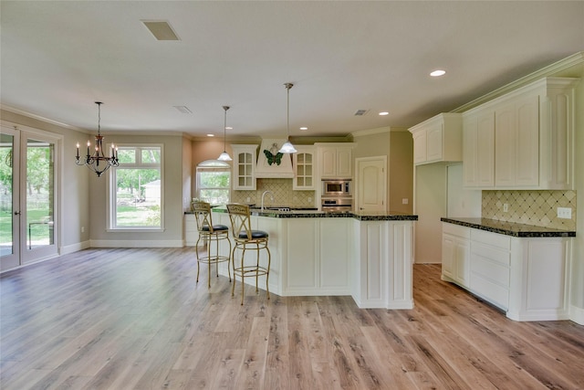 kitchen featuring glass insert cabinets, a sink, crown molding, appliances with stainless steel finishes, and decorative backsplash