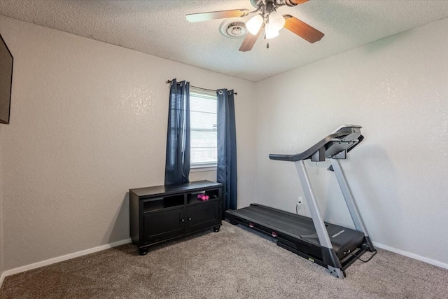 workout room featuring a ceiling fan, a textured ceiling, baseboards, light colored carpet, and a textured wall