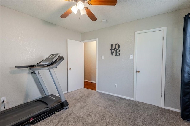 workout area with baseboards, ceiling fan, and carpet floors