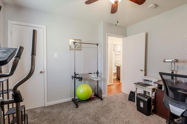 carpeted office featuring ceiling fan and a textured ceiling