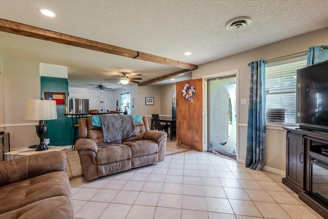 living area with beam ceiling, a textured ceiling, visible vents, light tile patterned flooring, and recessed lighting