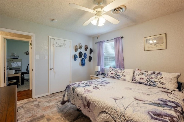bedroom with a closet, a textured ceiling, visible vents, a textured wall, and a ceiling fan
