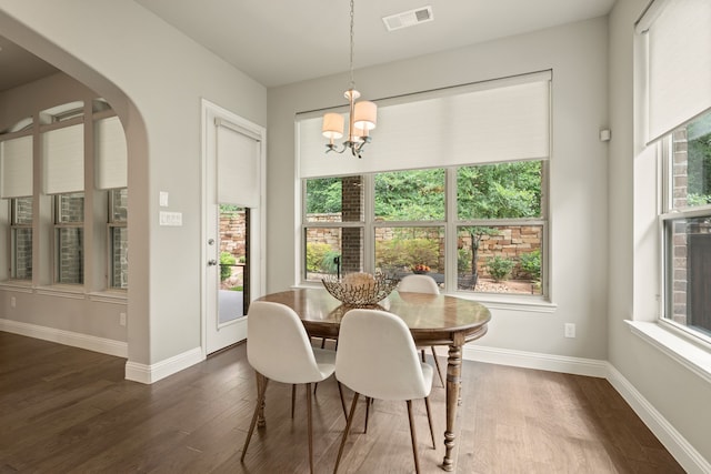 dining space with a wealth of natural light, visible vents, and dark wood-style flooring