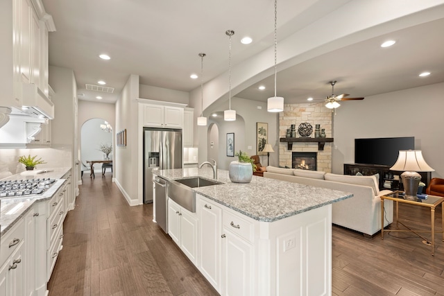 kitchen with a ceiling fan, a sink, stainless steel appliances, visible vents, and arched walkways