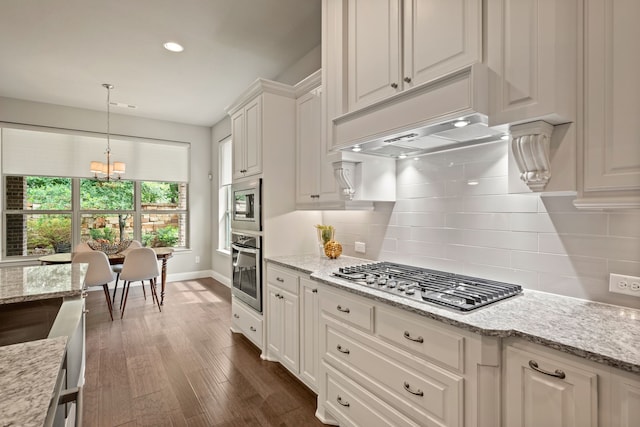 kitchen with pendant lighting, white cabinetry, a chandelier, stainless steel appliances, and tasteful backsplash