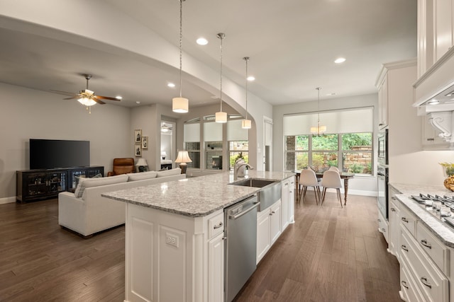 kitchen with a sink, dark wood-style floors, an island with sink, and appliances with stainless steel finishes