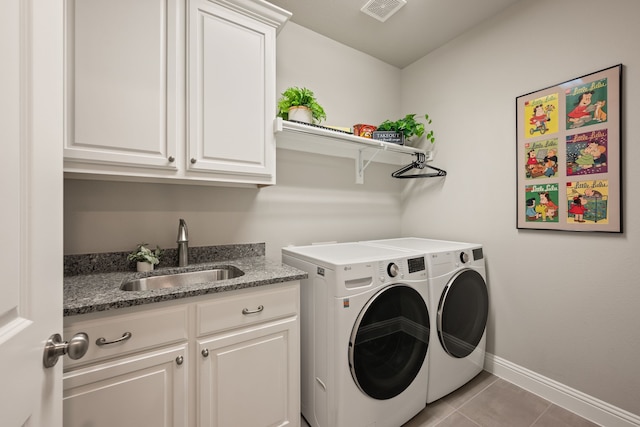 laundry room with baseboards, visible vents, a sink, washing machine and clothes dryer, and cabinet space