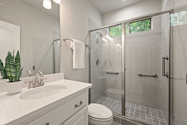 bathroom with vanity, toilet, and a shower stall