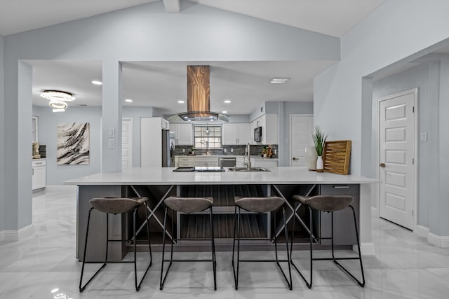 kitchen featuring lofted ceiling, marble finish floor, white cabinetry, decorative backsplash, and stainless steel appliances