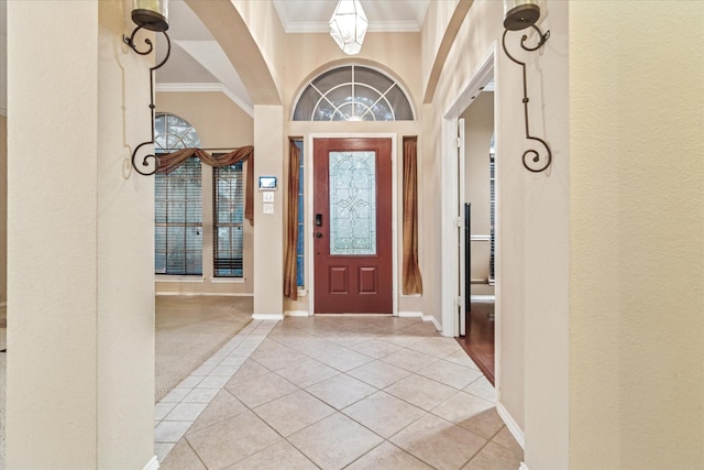 entrance foyer featuring light tile patterned floors, baseboards, and crown molding