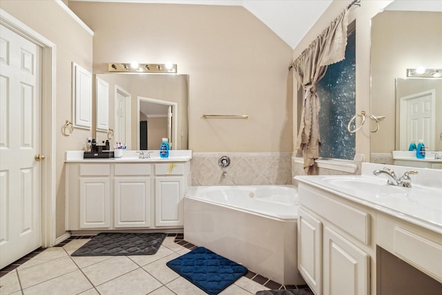 full bath featuring a garden tub, a sink, two vanities, tile patterned floors, and lofted ceiling