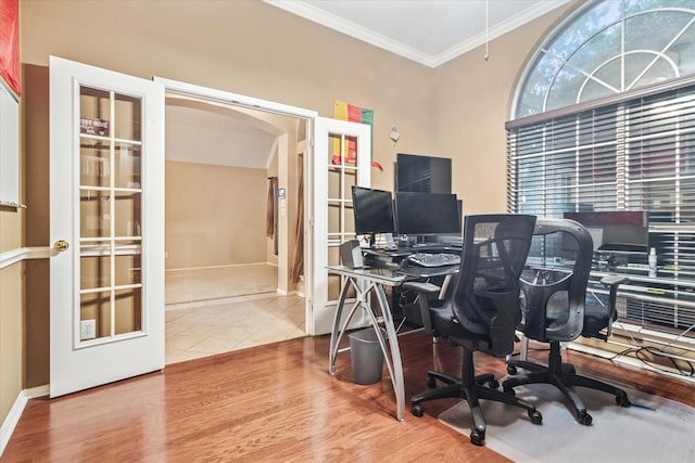 office area with ornamental molding, arched walkways, baseboards, and wood finished floors