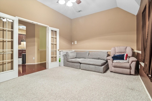 carpeted living room with vaulted ceiling, a ceiling fan, french doors, and visible vents