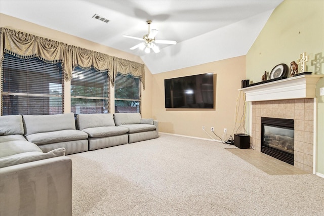 carpeted living room with a ceiling fan, a fireplace, visible vents, baseboards, and vaulted ceiling