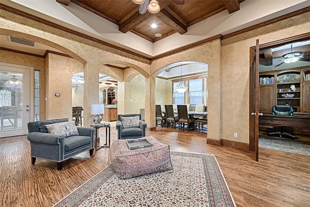 living room with beam ceiling, wood finished floors, visible vents, ceiling fan, and arched walkways