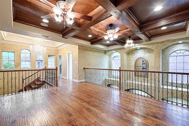 spare room with wood finished floors, visible vents, plenty of natural light, and ceiling fan with notable chandelier