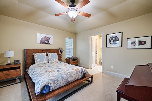 bedroom featuring baseboards, ensuite bath, ceiling fan, and light colored carpet