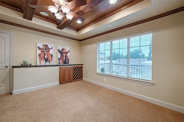 unfurnished room with baseboards, ornamental molding, wood ceiling, a raised ceiling, and light colored carpet