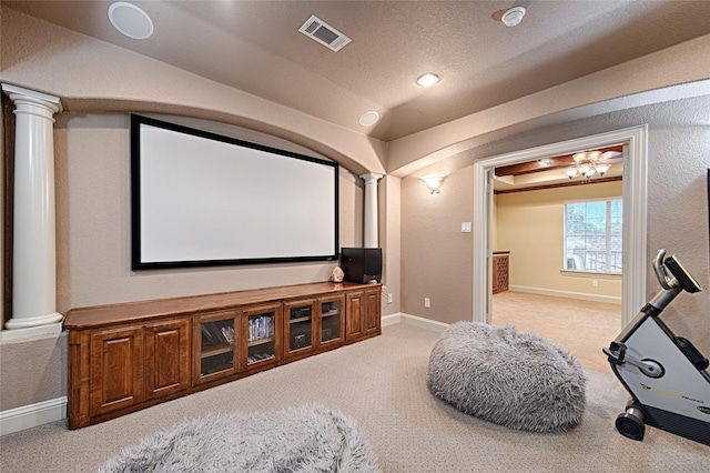 home theater room with vaulted ceiling, carpet, ornate columns, and visible vents